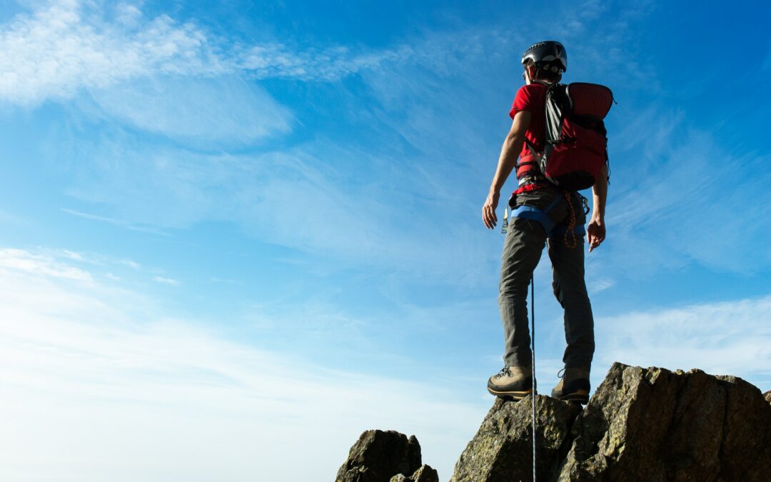 climber arrive on the summit of a mountain peak concepts victo