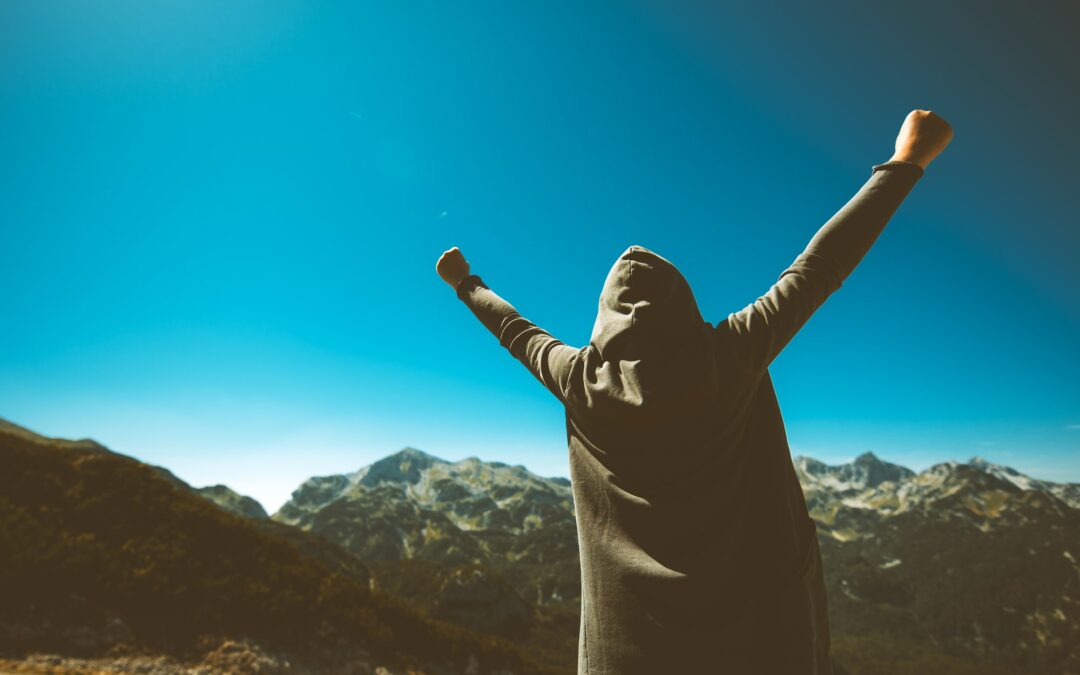 victorious female person on mountain top