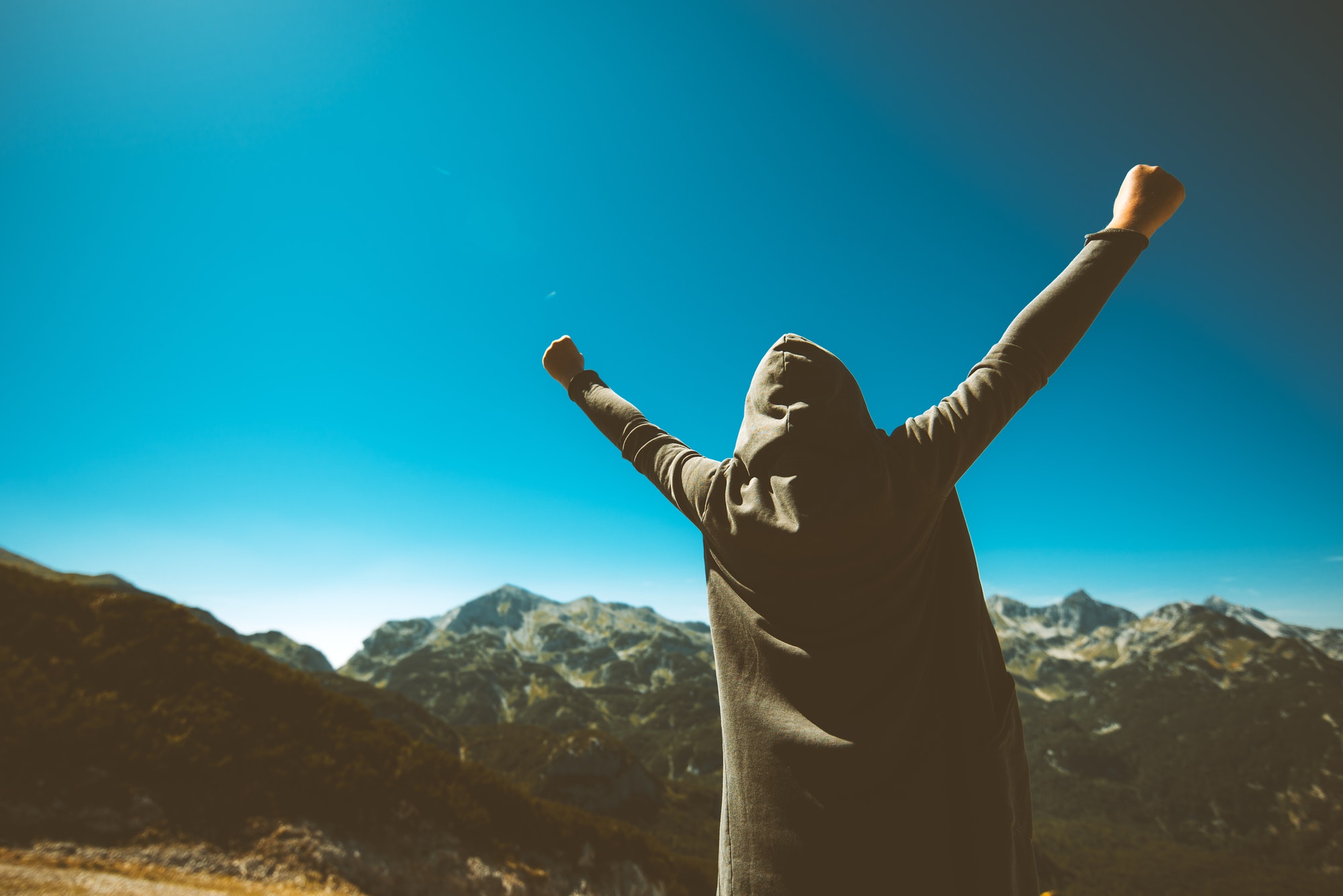 victorious female person on mountain top
